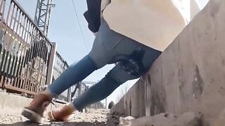 The very despairing woman was pissing in her jeans beside the railroad tracks