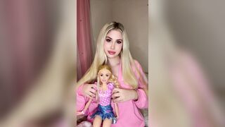 Ravishing blond girl in pink teasing with her doll