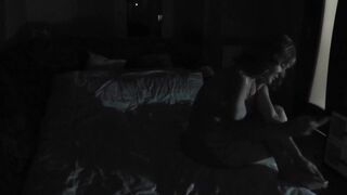 Spouse returned from work and screws his wife on bed in front of uncovered window . Married pair