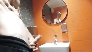 A slender dude with a bald head jerks off in a shopping mall WC