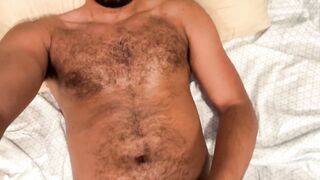 Unshaved dude stroking in daybed quickly cums on himself