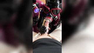 Latex Dommes in Gas Masks Taking Turns Sucking Their Sub’s Knob