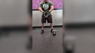 Muscle chap working out in the gym with kettlebell