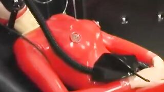 Sexy cutie full encased in red rubber costume enjoys gas mask breathplay in her ebony room