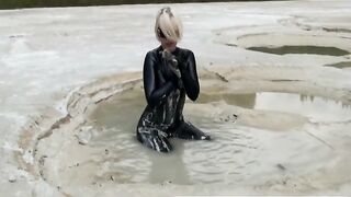 Super Sexy Blonde Angel In Ebony Latex Catsuit + High Heels And Sunglasses Bathes In The Mud - Mud Baths