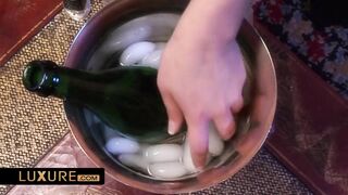 2 beautiful and breasty women use a Champagne bottle as a sex toy