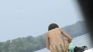 Topless sleek chicks on the exposed beach getting filmed by a voyeur